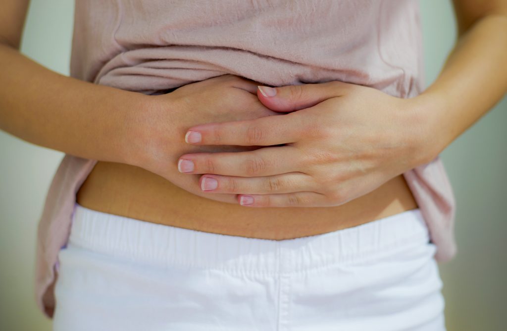 woman with pain has her hand on stomach